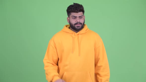 Sad Young Overweight Bearded Indian Man Giving Thumbs Down