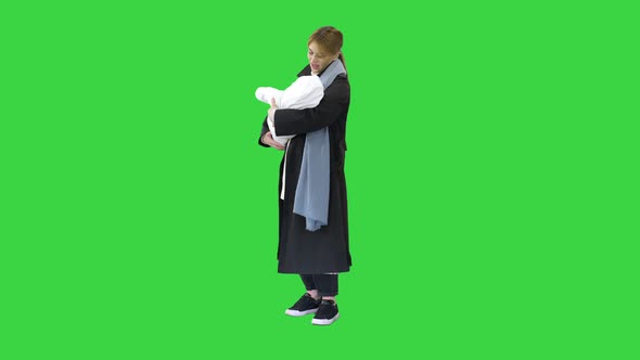 Young Mother with Her Baby Child Outdoors at Winter on a Green Screen, Chroma Key.