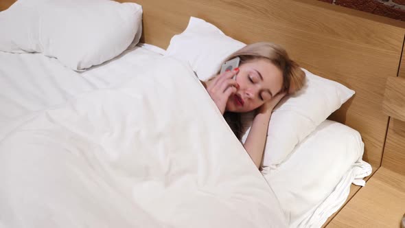 Woman Lying in Bed Talking on Mobile Phone