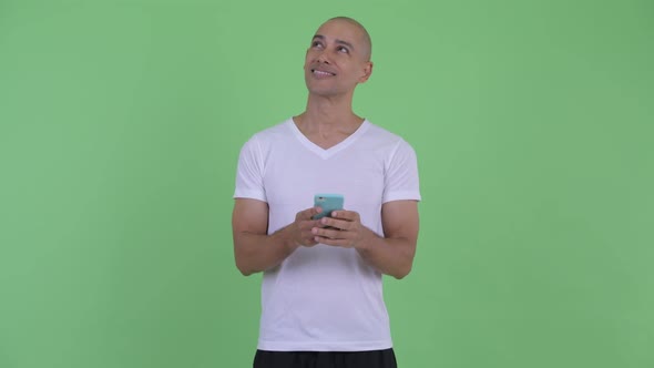 Happy Handsome Bald Man Thinking While Using Phone