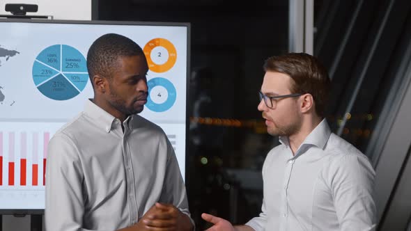 Young man discussing a new project with a colleague in the office