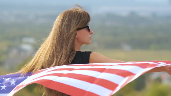 Young Happy Woman with Long Hair Holding Waving on Wind American National Flag on Her Sholders