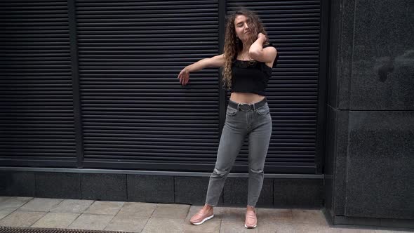 Young Playful Sexy Woman Is Posing on City Street and Joking