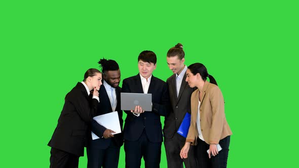 Group of Colleagues Discuss Project on Laptop on a Green Screen Chroma Key