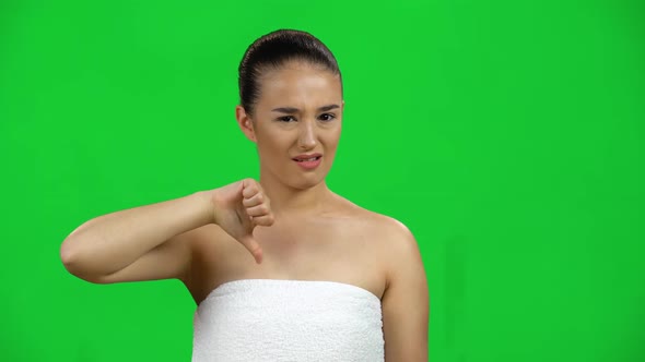 Unhappy Young Girl Showing Thumbs Down Gesture, Isolated on Green Screen at Studio