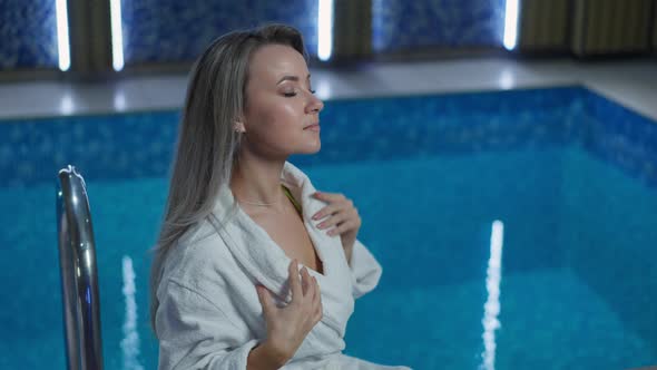 Confident Rich Caucasian Adult Woman Sitting at Pool in Luxurious Hotel Resting