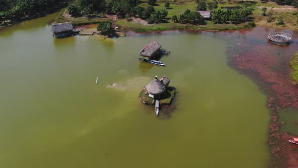4k Daytime aerial drone video looking at a small house built over the water with a boat parked in at