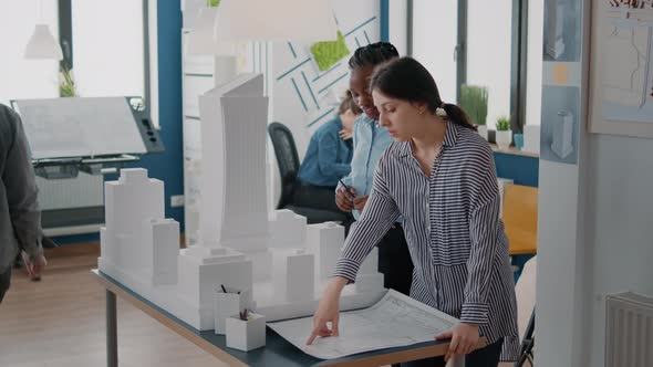 Multi Ethnic Women Analyzing Bulding Model and Blueprints Plan to Develop Construction