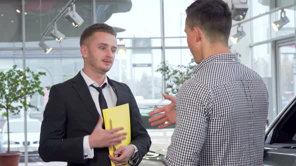 Car Salesman Giving Car Keys To the Customer After Shaking Hands