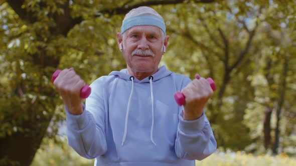 Senior Man Exercising Making Dumbbell Weight Lifting Exercises Practicing Sports Training in Park