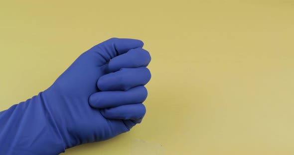 One Oval White Pill in Hand Dressed in Rubber Sterile Medical Glove