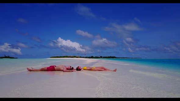 Two lovers relax on luxury coast beach break by blue sea with white sandy background of the Maldives