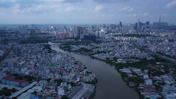 Aerial shot flying backwards over high density waterfront housing along a canal in Ho Chi Minh City,