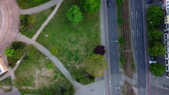From park to busy big street along houses.Fantastic aerial view flight drone shot footage from abov
