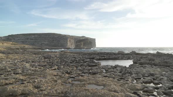 Walking Towards Fungus Rock on Stone Plateau near Azure Window in Gozo Island