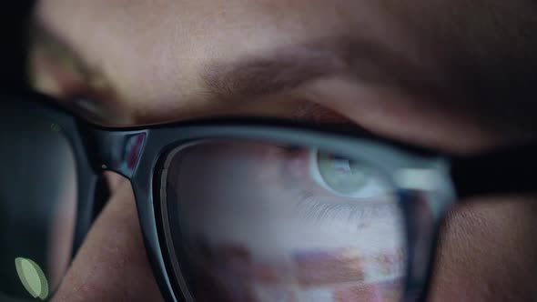 Woman in Glasses Looking on the Monitor and Surfing Internet. The Monitor Screen Is Reflected in the