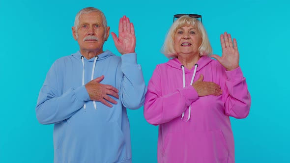 Sincere Responsible Senior Couple Man Woman Grandparents Raising Hands to Take Oath Tell Truth