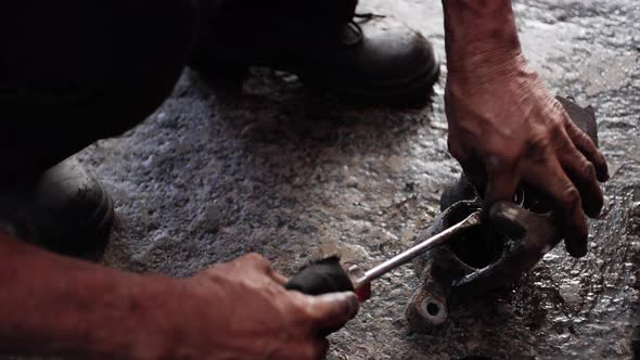 Old Latino Working In Mexican Mechanic's Workshop Maintaining And Changing Dirty Piston