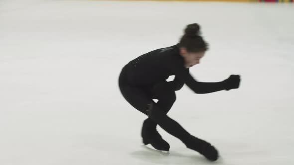 Little Girl Figure Skater in Black Training Costume Spinning Around on the Rink