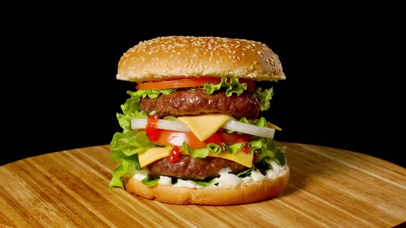 Great Burger with Beef Cutlet, Tomatoes, Mushrooms and Cucumbers with Melted Cheese Rotates on a