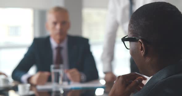 Close Up of Diverse Serious Businessmen Negotiate Contract in Office