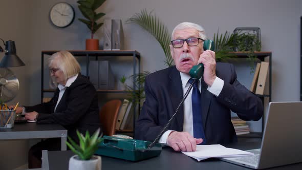 Annoyed Senior Businessman Talking on Retro Telephone Call Irritated Voice Dissatisfied with Work