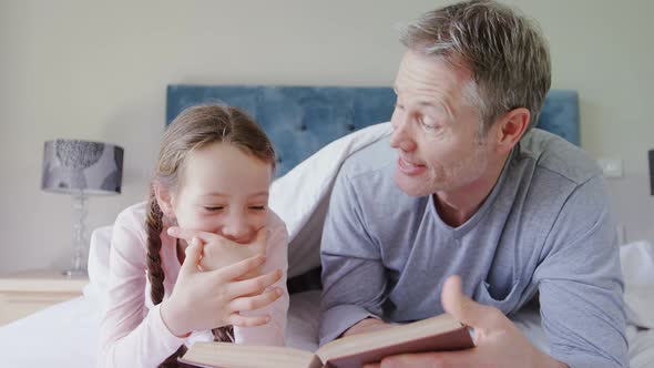 Father and daughter interacting with each other while reading a book 4k