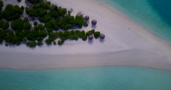 Daytime fly over clean view of a summer white paradise sand beach and blue sea background in 4K