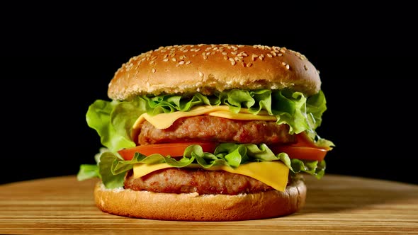 Great Burger with Beef Cutlet, Tomatoes, Mushrooms and Cucumbers with Melted Cheese Rotates on a