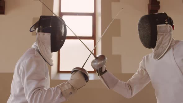 Fencer athletes during a fencing training in a gym