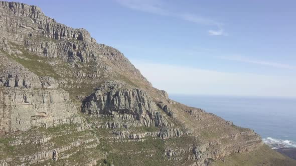 scenic aerial drone view ascensding over Table Mountain with its steep majestic rocky sandstone clif