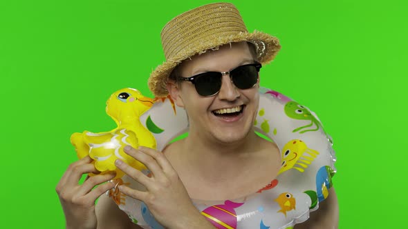 Shirtless Happy Man Tourist with Swimming Ring and Duck Toy Ask To Follow Him