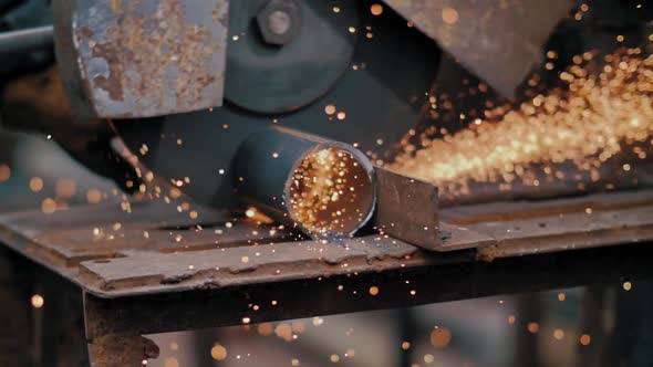 Closeup of Craftsman Sawing Metal with Disk Grinder in Workshop