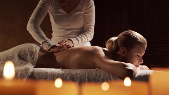 Young, healthy and beautiful woman gets massage therapy in the spa salon.