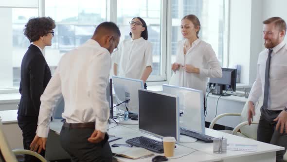 Colleagues Doing Exercises at Desks in Office