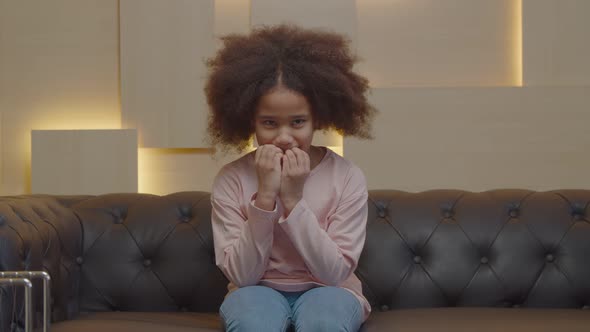 Portrait of Worried Preadolescent Black Girl Nail Biting During Therapy Session