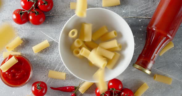 Dry Cannelloni Pasta Falling in Bowl on the Table