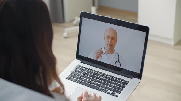 Woman Using Laptop and Talking Online with General Practitioner