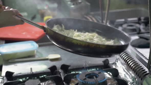 Close Up of Working Chef Preparing Chinese or Mexican Food Food Frying in Wok Pan