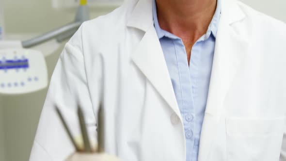 Female dentist holding dental tools