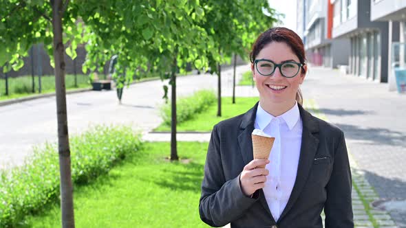 Business Woman Walks Outdoors and Enjoys Vanilla Icecream