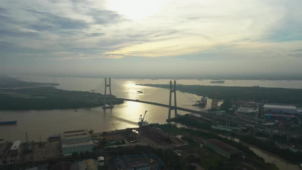 Fly in over urban area towards river and large modern suspension bridge in early morning light part