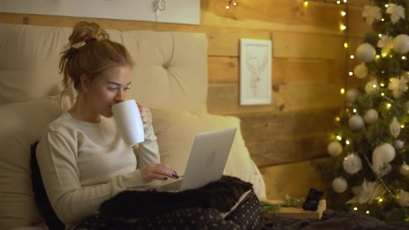 Happy Emotions of Young Woman in Leisure Wear Sitting on Bed Interacting with Boyfriend Via Laptop