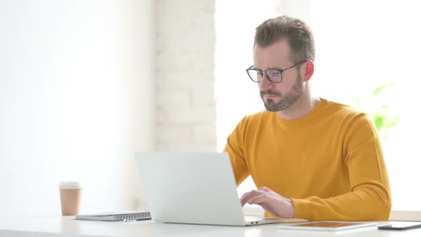 Man Working on Laptop in Office