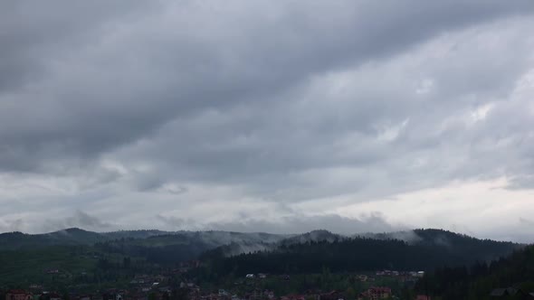 Dawn in Clouds Over Small Town in Mountains. Time Lapse