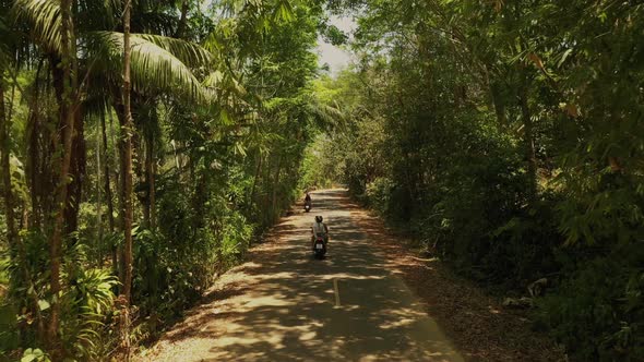 Couple of European Man and Woman in Helmets on Motorcycles Ride Along the Road