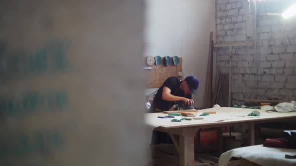 Carpentry Works Man Worker in Protective Glasses Grinding the Surface of a Wooden Detail in Workshop