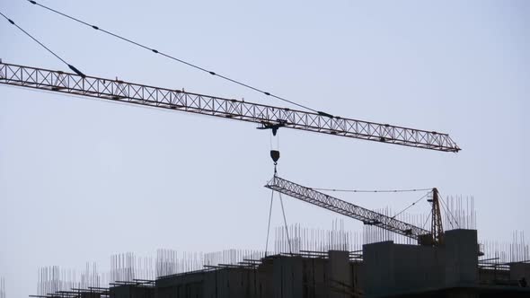 Tower Crane on a Construction Site Lifts a Load at High-rise Building.