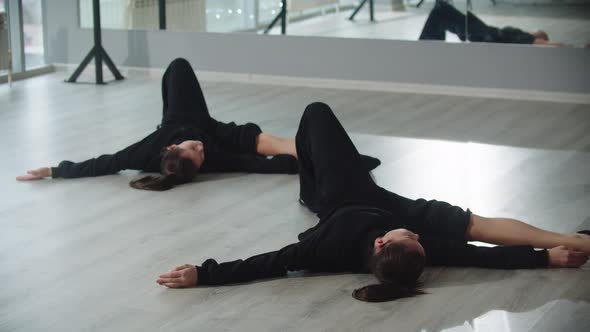 Little Girl Twins Synchronously Stretching in the Studio