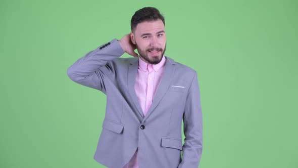 Confused Young Bearded Businessman Scratching Head